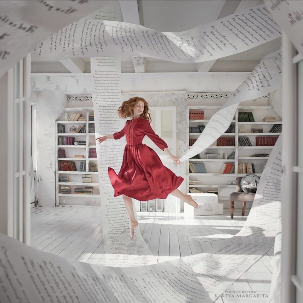 Photo d'une jeune fille russe dansant avec des pages de livres par Maria Kareva