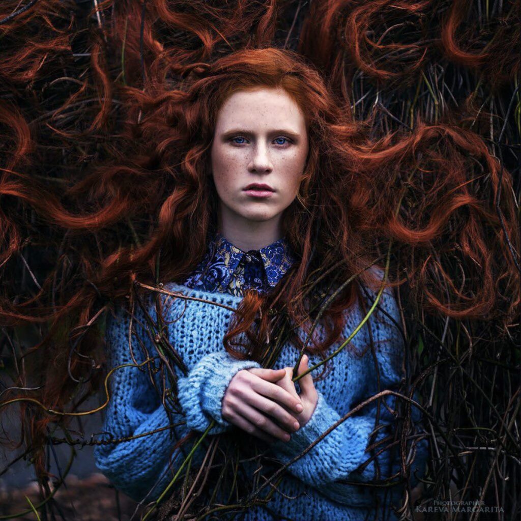 Portrait d'une jeune femme russe rousse aux yeux bleus tenant des branches, par Maria Kareva 
