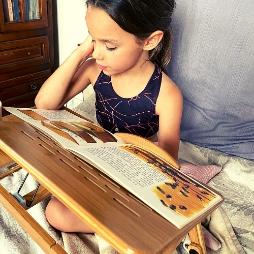 Une fille lit un livre pour enfant